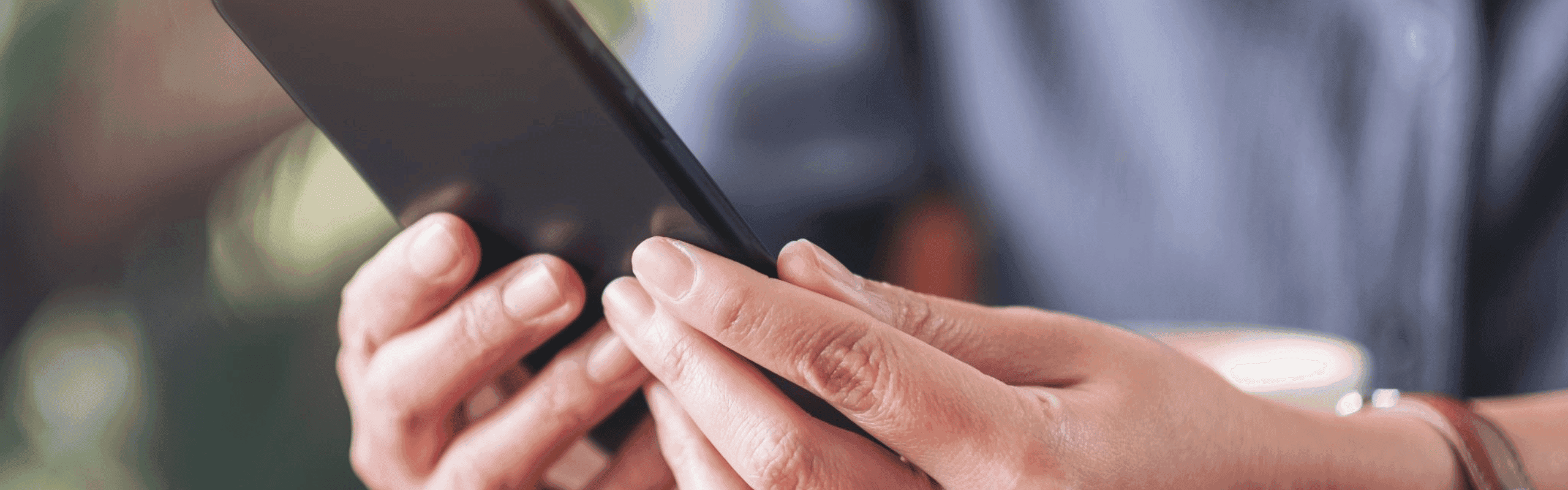 Zwei Hände halten ein Smartphone, das in Nahaufnahme betrachtet wird
